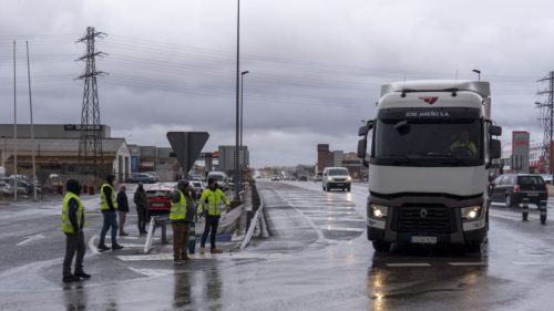 Poca incidencia en la huelga de transportistas: Un grupo de transportistas para camiones en una rotonda en la entrada de Teruel (EFE:Antonio García)